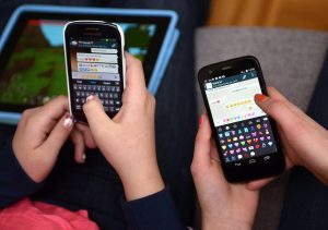 Manos de dos personas escribiendo mensajes de WhatsApp en sus teléfonos