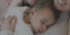 Bebé dormido sobre el pecho de un adulto que lo abraza