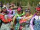 Mujeres y niñas mapuches con trajes tradicionales de colores y pañuelos en la cabeza durante una celebración al aire libre