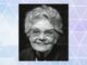 Retrato en blanco y negro de Mary Cover Jones sonriente, de edad avanzada y con gafas