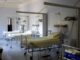 Habitación de hospital vacía con varias camas articuladas y equipos médicos junto a la pared