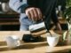 person pouring coffee in white ceramic mug