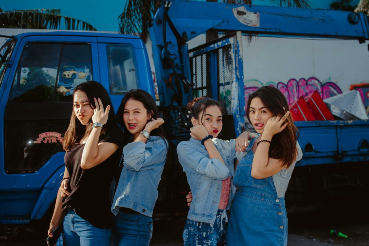 young women in casual wear standing in front of a truck