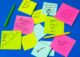 Notas adhesivas de colores con mensajes de ánimo como «Progress not perfection» y «You can do it!»