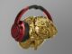 Cerebro dorado con auriculares rojos puestos, sobre fondo gris