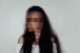 Retrato de una mujer de pelo largo con el rostro borroso por el movimiento, sobre fondo gris