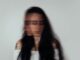 Retrato de una mujer de pelo largo con el rostro borroso por el movimiento, sobre fondo gris