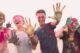 Grupo de jóvenes sonrientes con las caras y las manos manchadas de polvo de colores