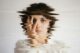 Retrato de una mujer joven con la mano en la cara, distorsionado por ondas como si se reflejara en el agua