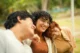 Tres jóvenes adultos sonríen juntos al aire libre