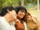 Tres jóvenes adultos sonríen juntos al aire libre